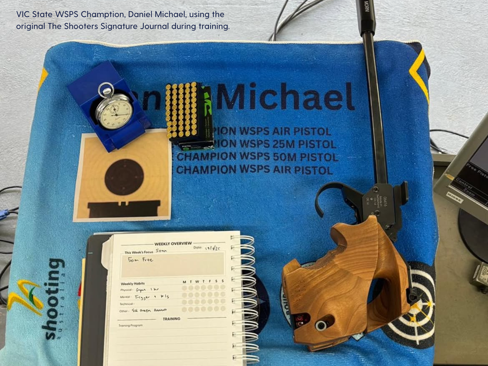 First prototype of The Shooters Signature Journal on a bench with a Morini free pistol and range towel that says WSPS champion. 